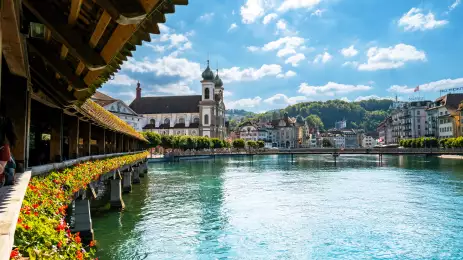 Jesuitenkirche Rathaussteg bridge over blue water with buildings in the background, Lucerne, Swizerland