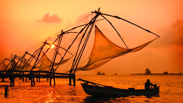 A sunset over fishing nets and boat in Cochin (Kochi), India