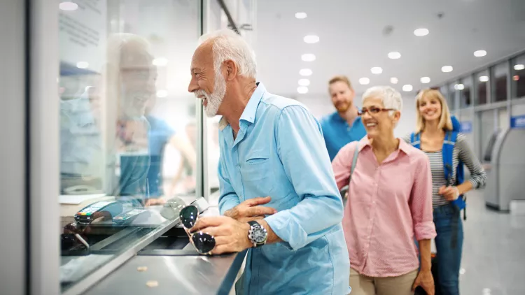 A happy elderly couple validating tickets at an airport