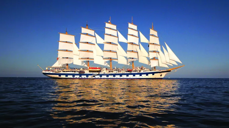 Exterior shot of the Royal Clipper ship at sea against a dark blue sky