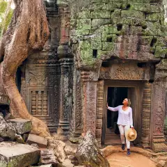 Image of woman looking upwards in the doorway of ancient ruins in a rainforest