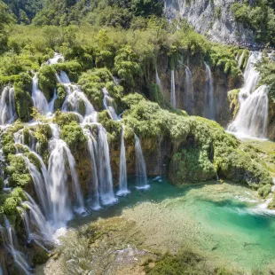 Croatia waterfalls with tourists overlooking the beautiful view from a nearby hanging bridge