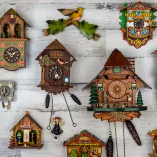 Antique cuckoo clocks on a white wall