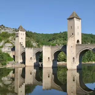 Pont Valentré Bridge reflecting it's image in the Lot River, Cahors, France