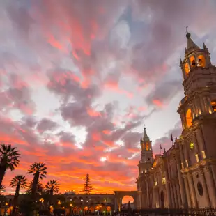 Stunning colorful sky and clouds at dusk in Arequipa, famous travel destination and landmark in Peru. Wide angle view from below of the colonial Cathedral. Panoramic frame.