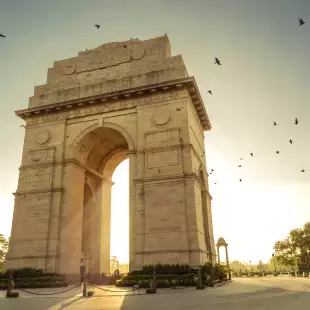 Sunrise over the India Gate, stone monument archway in New Delhi, India