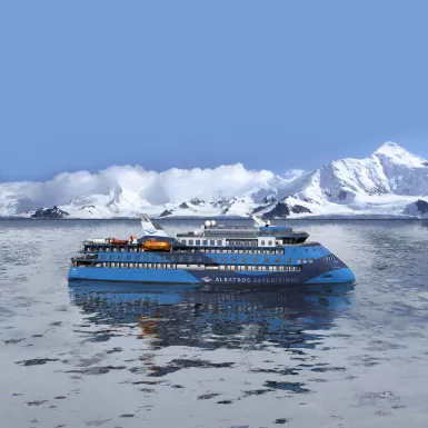 Exterior of the Ocean Albatros ship with snowy mountains in background