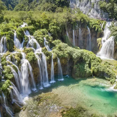 Croatia waterfalls with tourists overlooking the beautiful view from a nearby hanging bridge