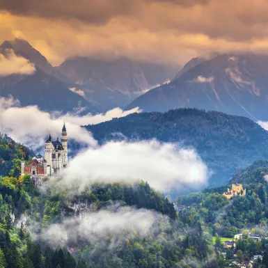 Neschwanstein Castle with vegetation and mist in the Bavarian Alps, Germany