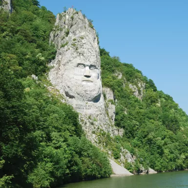 A large rock sculpture of decebalus overlooking the Danube River gorge 