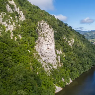 A large rock sculpture of decebalus overlooking the Danube River gorge 