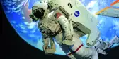 Floating astronaut in a white space suit with the earth behind them