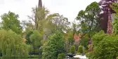 Minnewater Lake with obscured views of Bruges through the treeline 