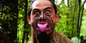 Maori man with his tongue stuck out in a Pūkana, an expression worn for when performing a Haka or song