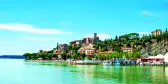 Brightly coloured Lake Trasimeno with anchored boats in the province of Perugia, Umbria, Italy.