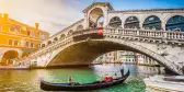 Gondola on Canal Grande with Rialto Bridge at sunset in Venice, Italy