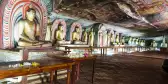 Interior of the Dambulla Golden Cave Temple with rows of golden Buddha statues and painted ceilings, Sri Lanka, South Asia.