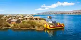 The floating islands on Titicaca Lake, featuring moored kayaks and wooden cabins