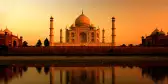 Taj Mahal at sunset with golden sky being reflected in water, Agra, India