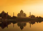 Taj Mahal at sunset reflected in the calm Yamuna river in India