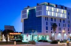 Exterior view of the Hilton Garden Inn illuminated at night in Lecce, Italy