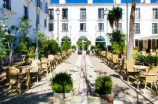 Courtyard of the Ilunion Hacienda de Mijas Hotel under midday light, lined with patio furniture