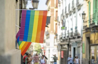 A rainbow gay pride flag hanging in the streets of Madrid