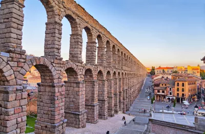 Roman aqueduct of Segovia under a sunset sky