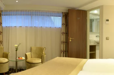 Interior of bedroom with table and chairs aboard the Jane Austen ship