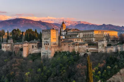 Arabic palace Alhambra with Sierra Nevada mountains in the background at twilight in Granda, Spain