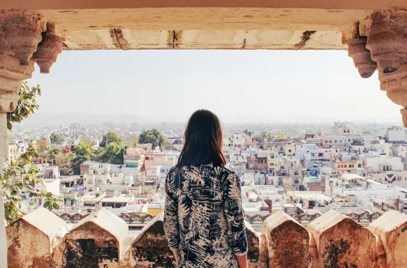 A young woman looks out over the city of Udaipur, Rajasthan, North India.