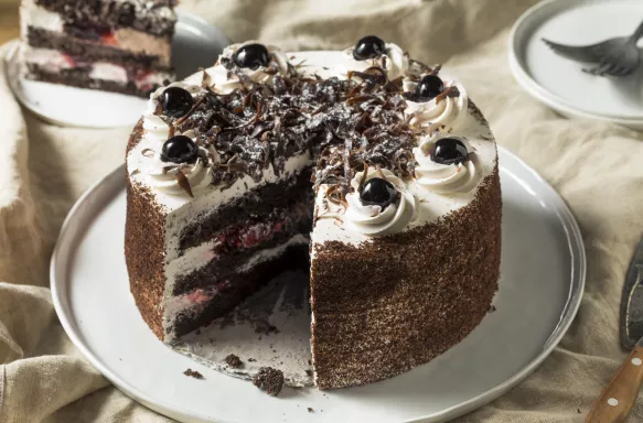 Sweet homemade black forest cake with a slice taken out of it