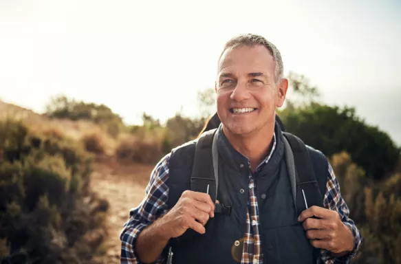 Shot of a mature man smiling whilst hiking through the mountains