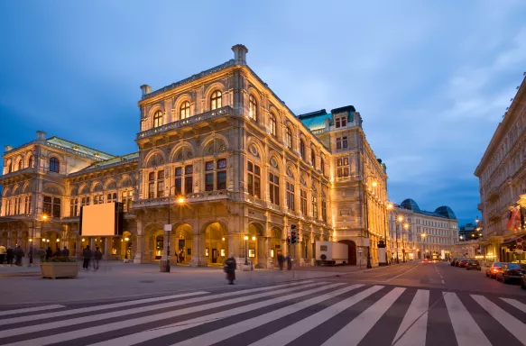 The Opera House in Vienna, lit up in the evening.