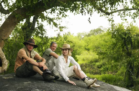 Senior man and couple sitting on a rock at the Safari in Mpumalanga province, South Africa.