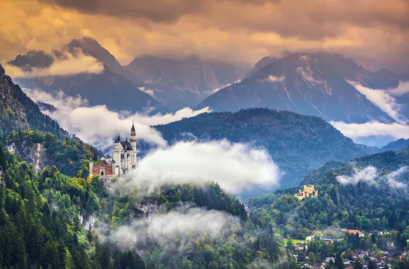 Neschwanstein Castle with vegetation and mist in the Bavarian Alps, Germany