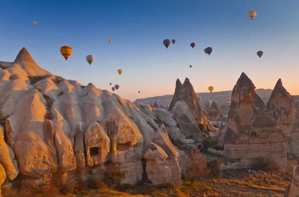 Hot air balloons rising up in the sky, in Cappadocia, Turkey.