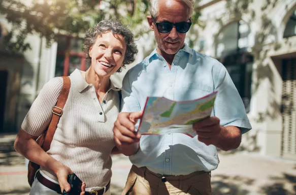 Mature man and woman using map while sightseeing