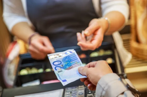 Woman is paying In cash with euro banknotes