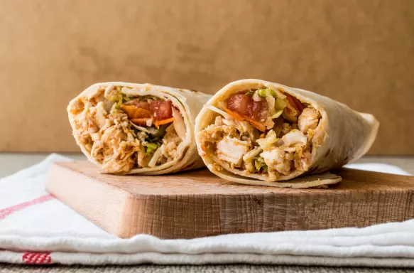 Chicken Shawarma Doner kebab wraps on a wooden cutting board