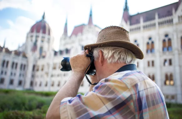 Senior man photographing the Parliament building in Budapest, Hungary.