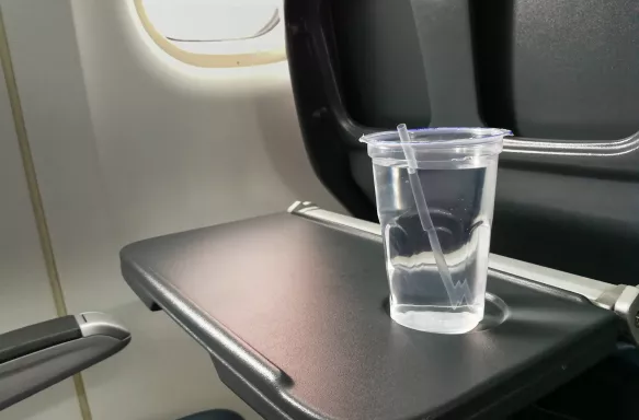 Disposable refreshing mineral water on table in air plane cabin.