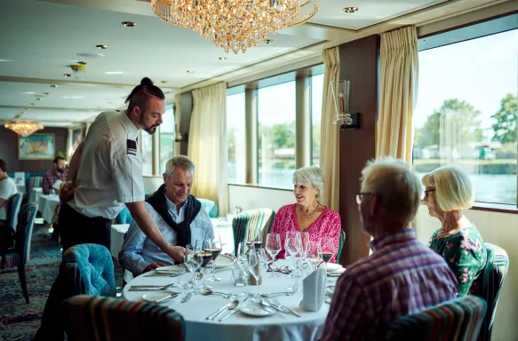 Senior friends dining together aboard a ship