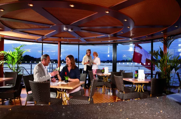 The Lido Bar aboard the MS Lord Byron with couples enjoying a drink