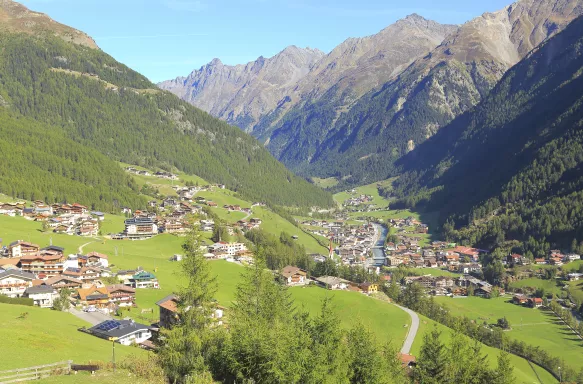 Large green hills with houses along the edges, in Soelden