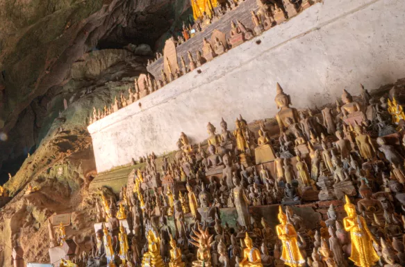 Hundreds of Buddha carvings lined up in Pak Ou Caves, Luang Prabang, Laos