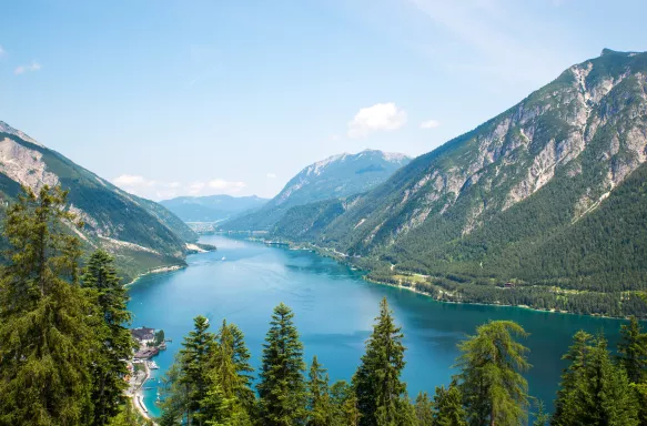 Alpine lake with fir trees and distant mountains  in Tyrol, Austria