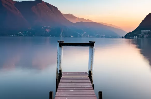 Sunset at Lake Lugano from wooden jetty in Switzerland