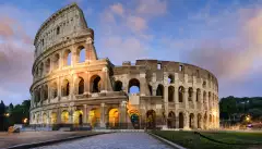 Image of the historical Colosseum in Rome against a sunset sky