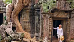 Image of a woman looking up in the ruins of an ancient temple in the rainforest